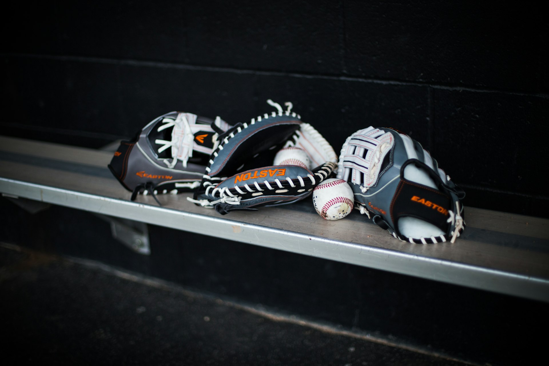 a pair of baseball gloves sitting on top of a metal shelf